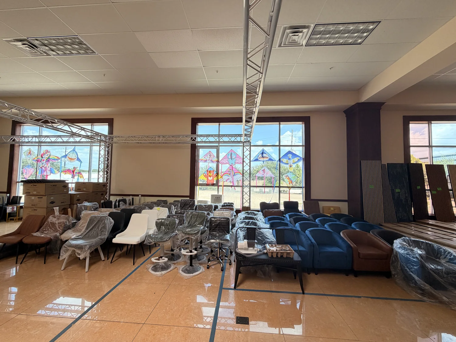 Dining chairs, accent chairs and bar stools wrapped and lined up in rows along the windows of the Cube-Age Houston sale floor