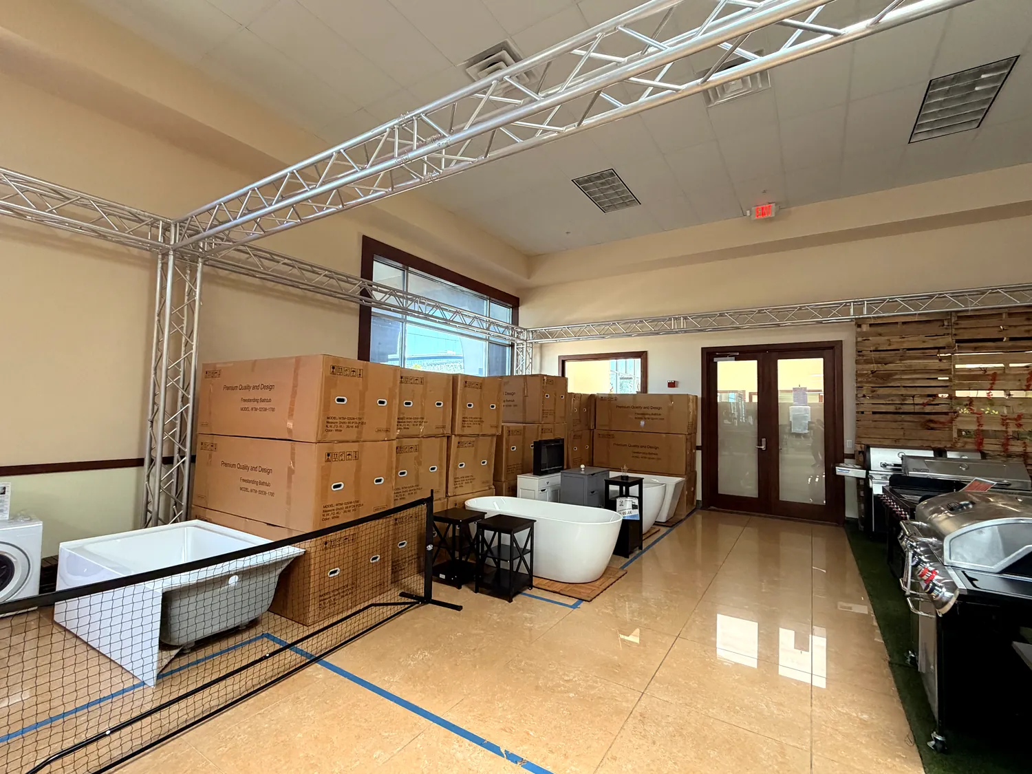 Boxed goods and bathtubs staged in marked booth zones