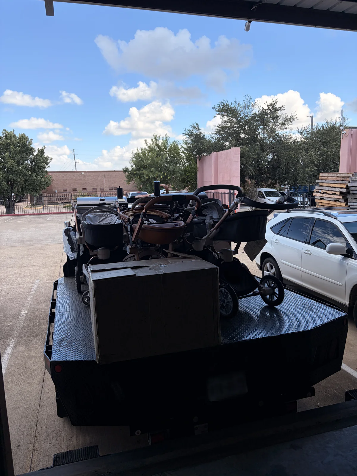Flatbed trailer loaded with baby strollers and prams outside the Cube-Age Houston warehouse