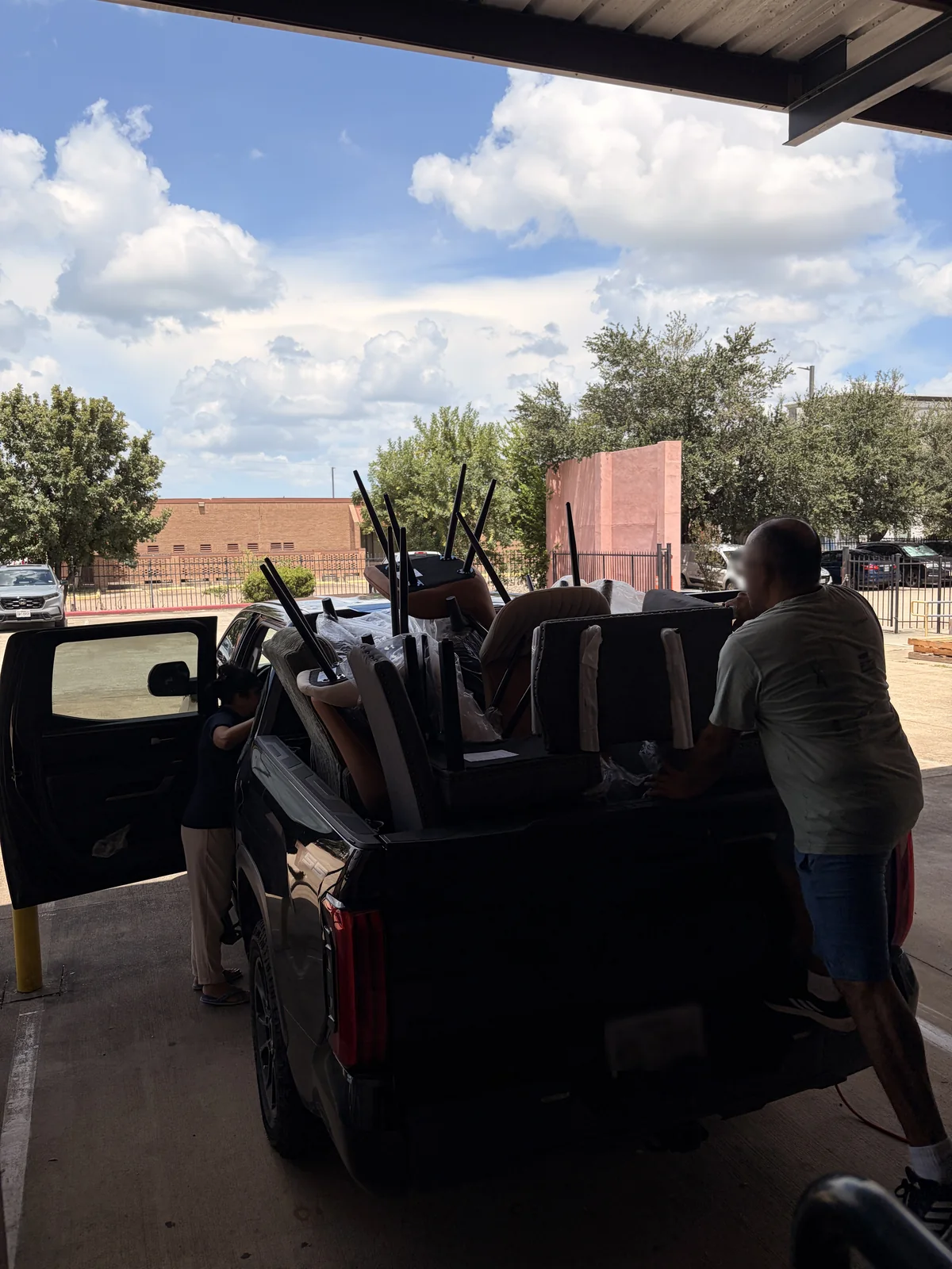 Chairs and a mattress being loaded into the bed of a pickup truck at the Cube-Age loading dock