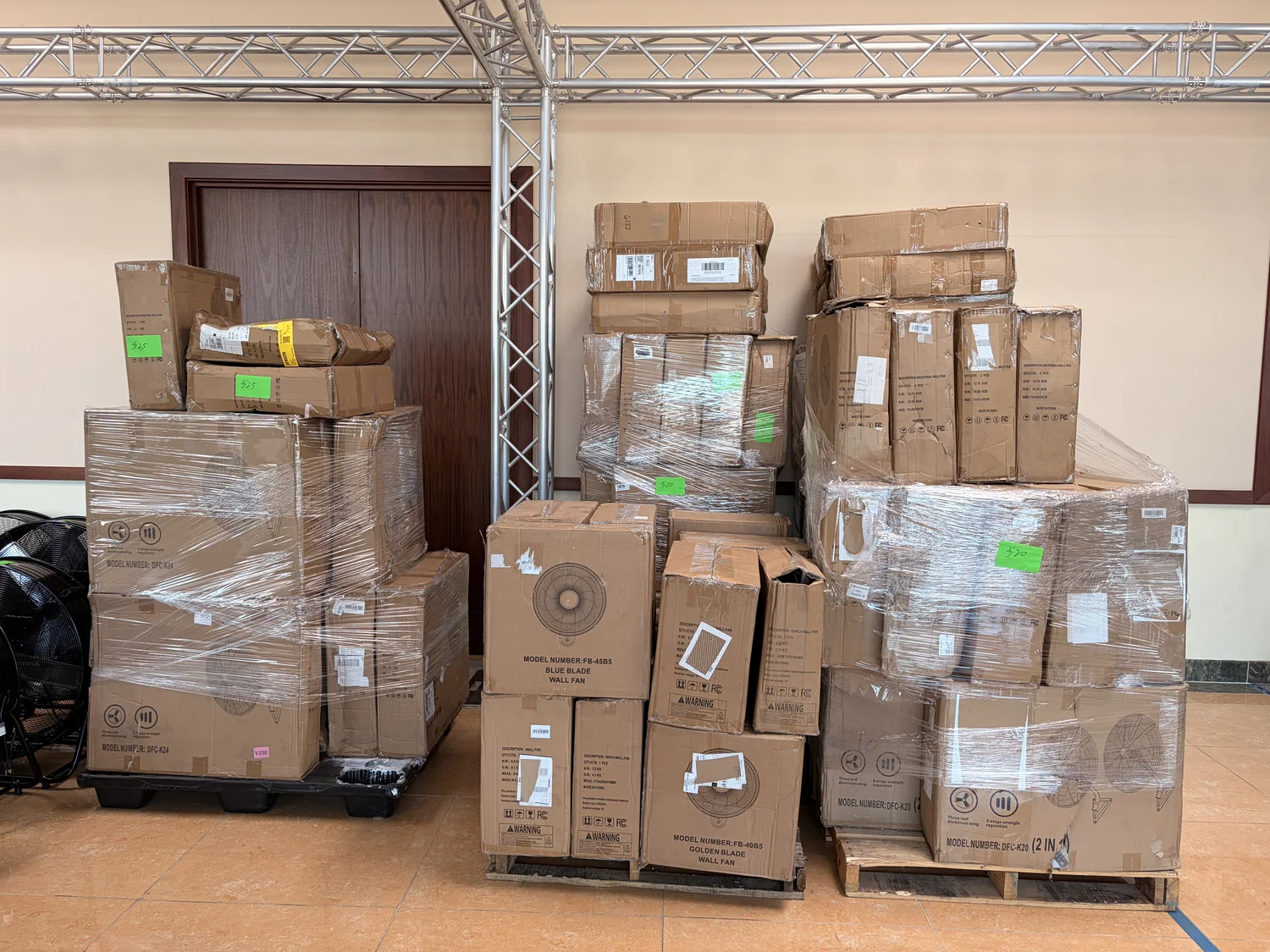 Pallets of boxed wall fans and drum fans wrapped and price-tagged on the Cube-Age Houston sale floor