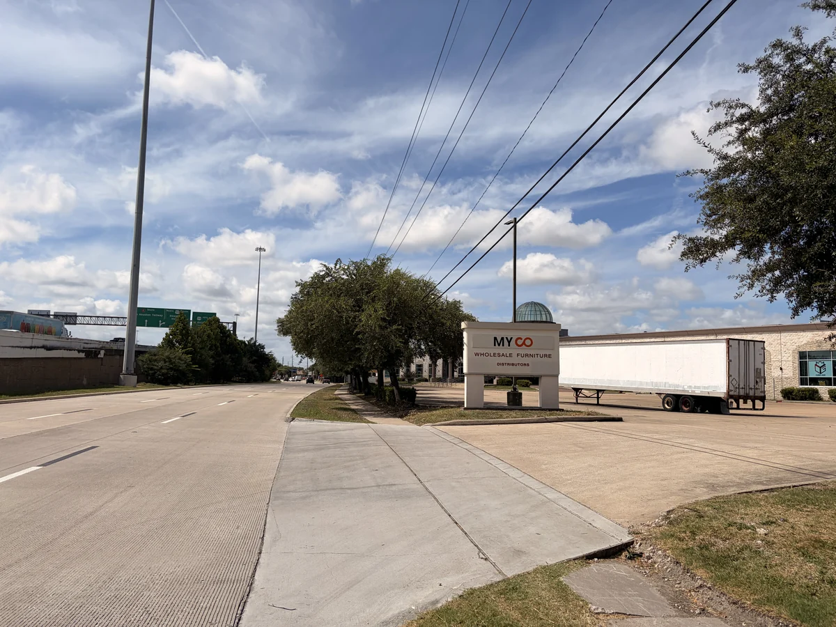 The MYCO Wholesale Furniture Distributors sign at the driveway on W Sam Houston Pkwy S