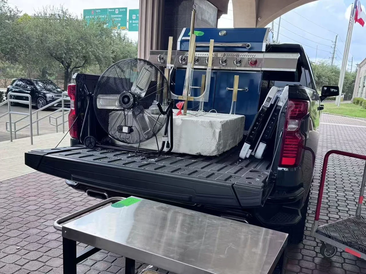 A customer pickup loaded with a gas grill, a floor fan and a griddle cart outside the Cube-Age Houston sale