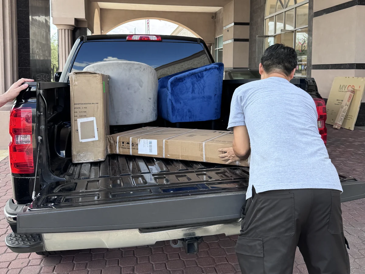 A pickup bed loaded with an armchair and boxed goods at the Cube-Age Houston sale