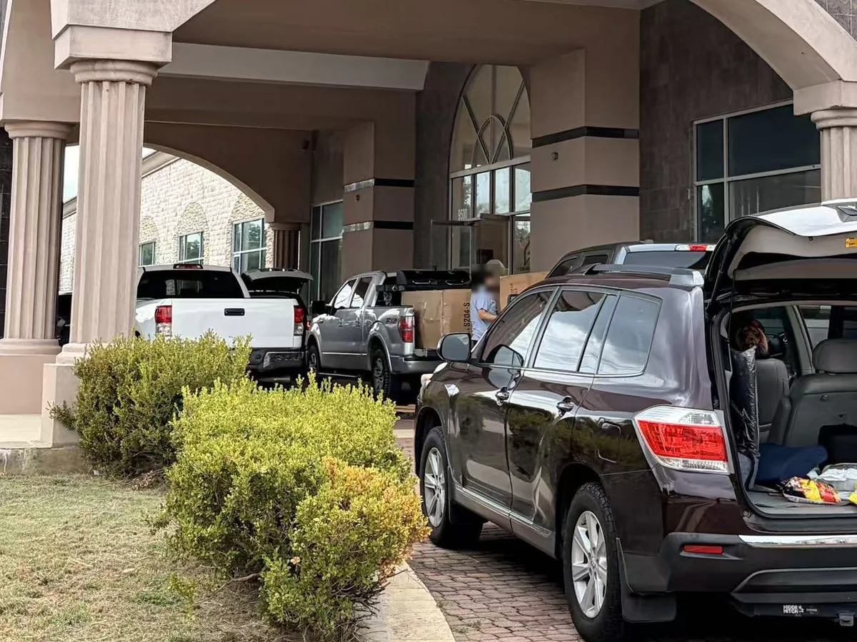 An SUV with its hatch open, loading in front of the Cube-Age Houston sale building