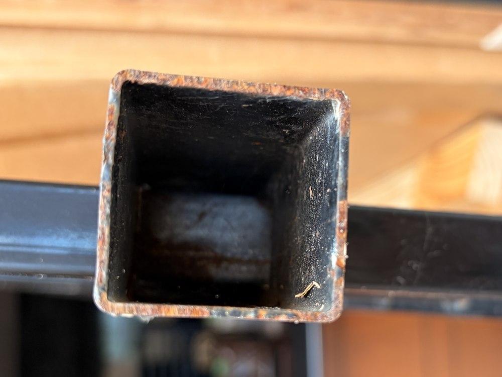 A ring of rust around the cut end of a powder-coated steel fence rail