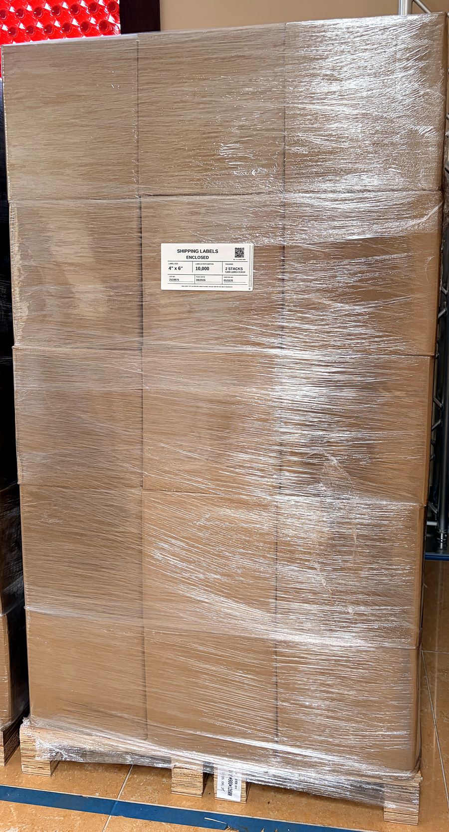 A full pallet of Bright Labels shipping-label cartons, stretch-film wrapped, with the packing label on the front, in the Cube-Age Houston warehouse