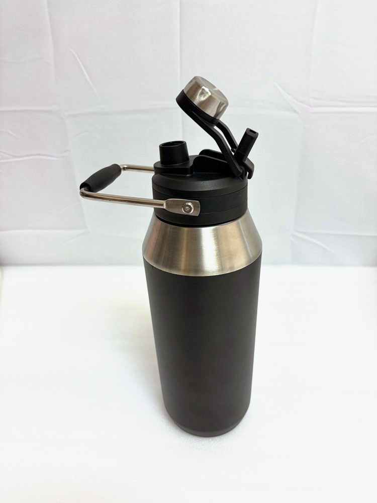A large black stainless steel bottle with a wire carry handle