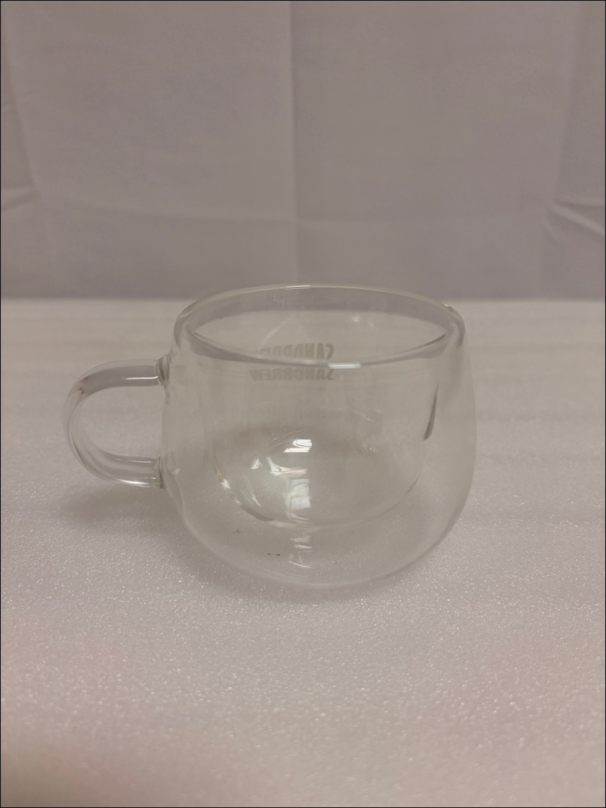 A small double-wall glass cup with a handle