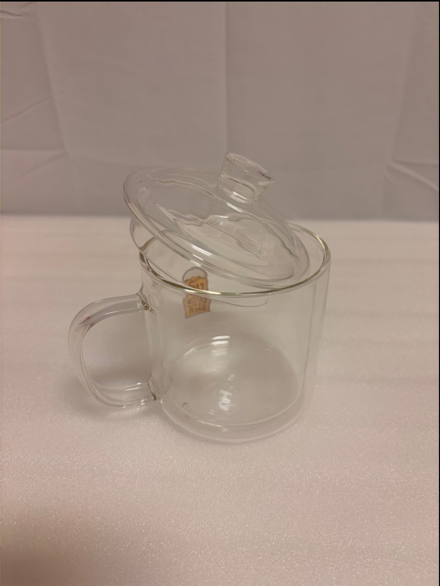 A lidded double-wall glass pot with a handle