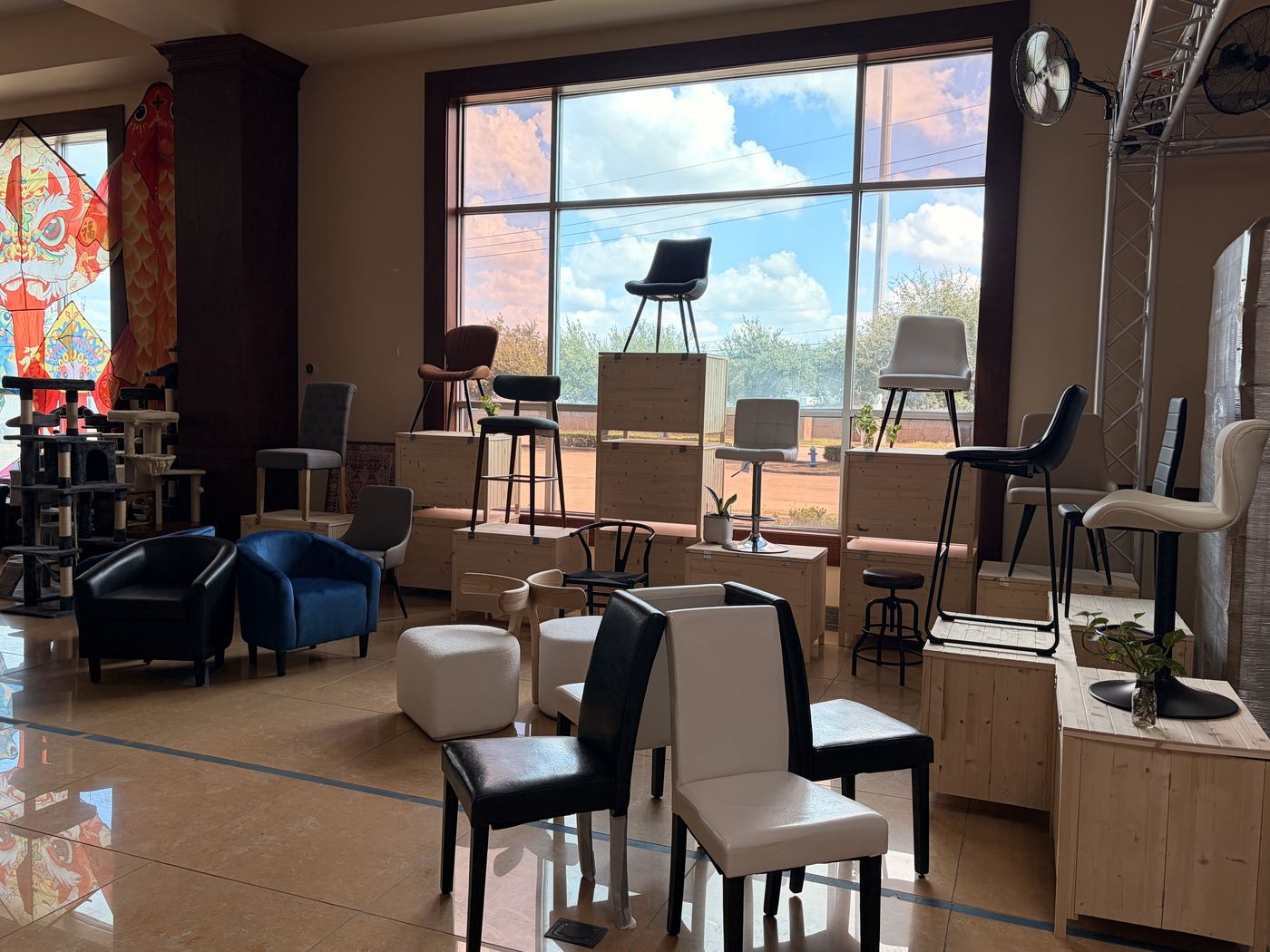 The finished seating zone in the Cube-Age showroom: dining chairs, bar stools and armchairs on timber risers along the window