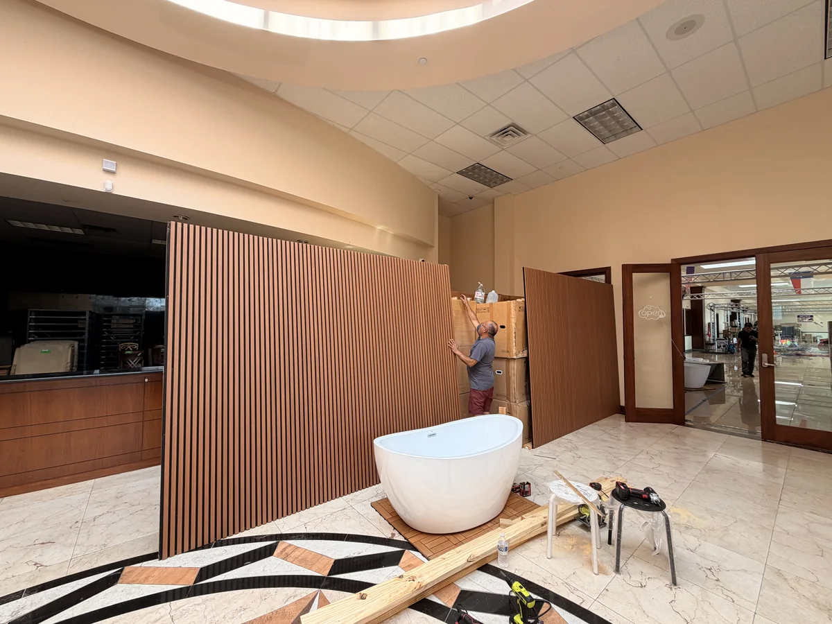 A slatted wall panel partition being installed at the Cube-Age showroom entrance
