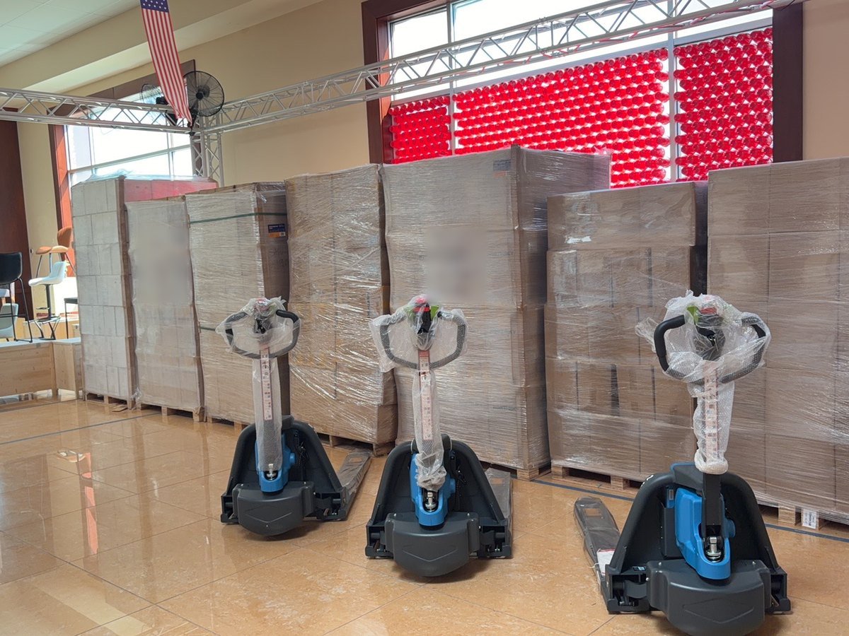 Electric pallet jacks in front of wrapped pallet stock in the Cube-Age warehouse supply area