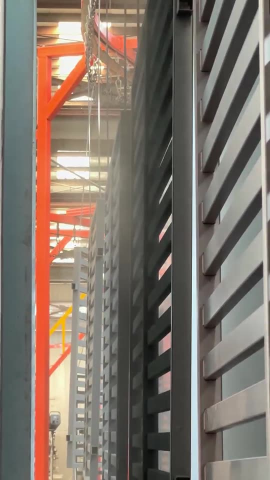 Racked panels passing the electrostatic powder spray guns